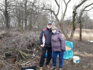 Seniorzy wydobywają zakopane słoiki z ziemi w ogrodzie społecznym w Cieplicach